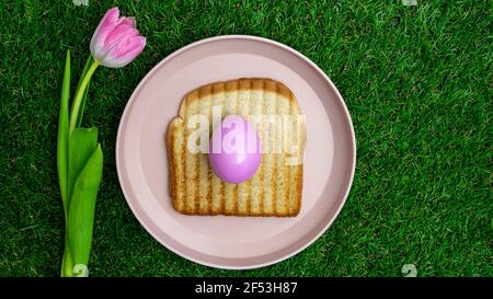 Pink colored tulips with a pink Easter egg over a toasted bread in plate. Stock Photo