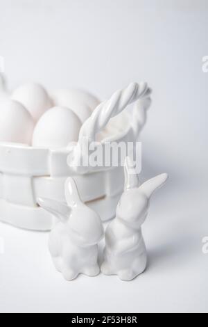 White porcelain Easter bunny and egg corp with white eggs on white background. Stock Photo