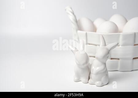 White porcelain Easter bunny and egg corp with white eggs on white background. Stock Photo