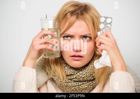Girl hold glass water tablets and thermometer light background close up. Get rid of flu. Getting fast relief. Ways to feel better fast. Flu home Stock Photo