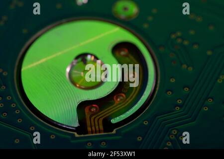 Macro photography  of hard drive internal mechanism hardware selective focus, in green blue light. Stock Photo