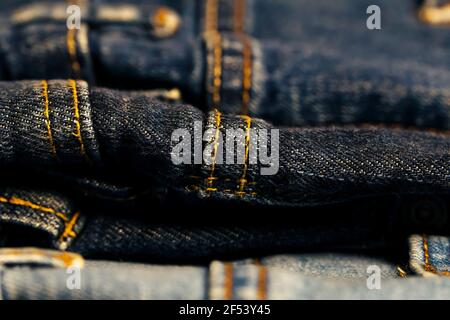 Different denim pants with Thick yellow thread. Stock Photo