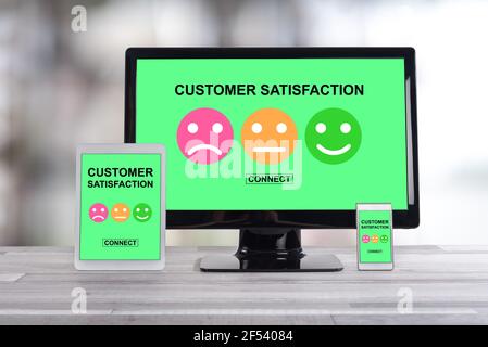 Customer satisfaction concept shown on different information technology devices Stock Photo