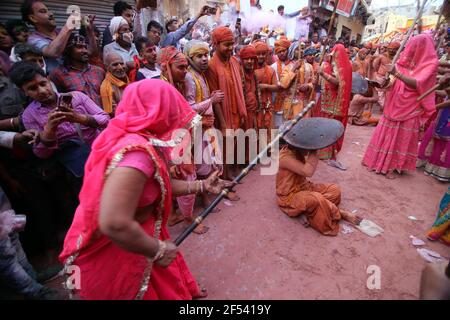 New Delhi. 23rd Mar, 2021. Indian women from Barsana village beat a villager from Nandgoan with wooden sticks during Lathmar Holi festival celebrations at Barsana village in Uttar Pradesh, India on March 23, 2021. Credit: Str/Xinhua/Alamy Live News Stock Photo