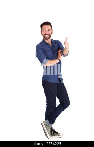 Full length portrait of confident mature man standing and showing thumbs up over white background Stock Photo