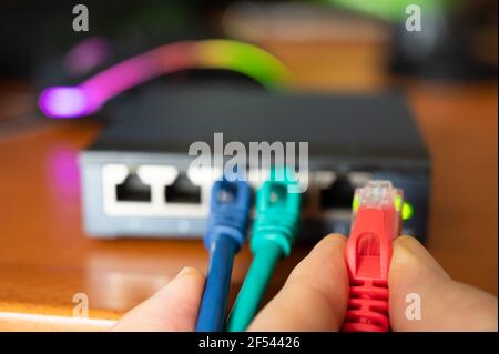 Close-up image of a router: the connections of the three red, green and blue ethernet cables are tested. Concept of cabling, internet network, working Stock Photo