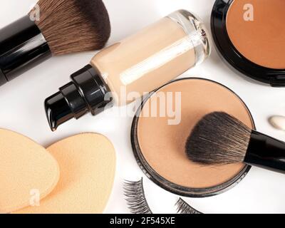 Foundation, powder, concealer, make up brushes, make-up sponges, false eyelashes on white background Stock Photo