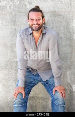 Portrait of smiling man leaning forward with hands on knees Stock Photo