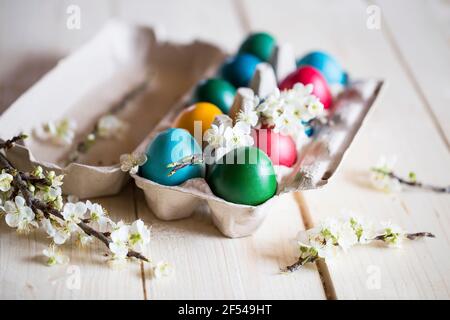 Festive colorful Easter eggs with spring flowers, Easter holidays decoration with hand-painted Easter eggs and spring blossom branches Stock Photo