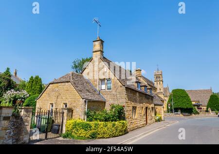 Typical roadside Cotswold stone slate roof houses and St Catharine's Church in Chipping Campden, a small market town in the Cotswolds, Gloucestershire Stock Photo