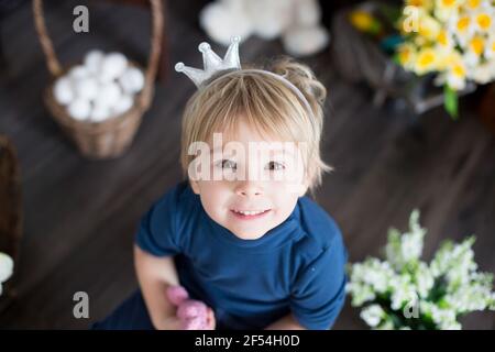 Beaufitlu toddler blond boy, wearing little crown, pretending to be prince, child playing imaginary games Stock Photo