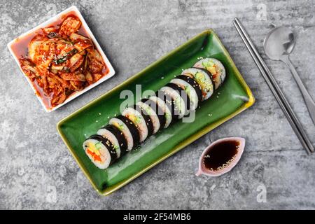 Korean food, Gimbap or Kimbap is seaweed rice roll and kimchi side dish. Stock Photo