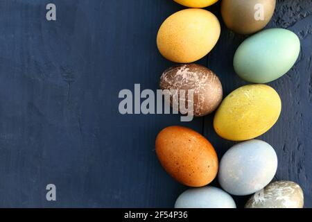 Colorful Easter eggs on dark wooden background. Natural coloring of Easter eggs. Stock Photo