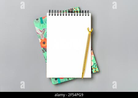 open notepad, golden pen on gray background, spiral notebook on table Business, planning, education, morning life working from home concept Top view F Stock Photo