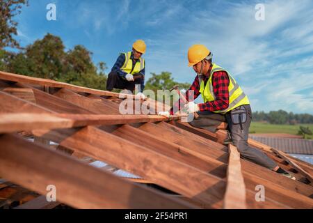 Roofer, Two roofer carpenter working on roof structure on construction site, Teamwork construction concept. Stock Photo