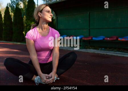 The athlete sits and normalizes her body after a strenuous workout Stock Photo