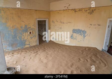 View inside a room with sand at German Kolmanskop - Kolmannskuppe Ghost Town in Namibia with the abandoned buildings in the Namib desert Stock Photo