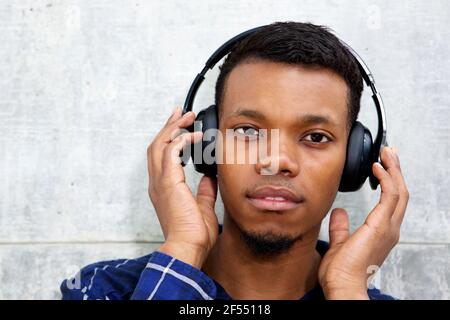 Close up portrait of handsome black man listening to music with headphones Stock Photo