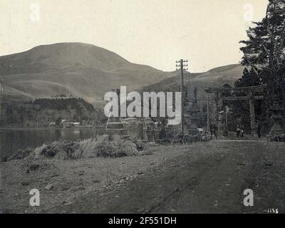 Hakone. Way at Ashi Lake in the Fuji National Park with Fingering Tele, Stone Lanterns and Torii (entrance to a Shint? -Chein) Stock Photo