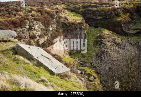 Discarded anchor plate on the side of a disused and unfenced quarry on moorland in Yorkshire Stock Photo