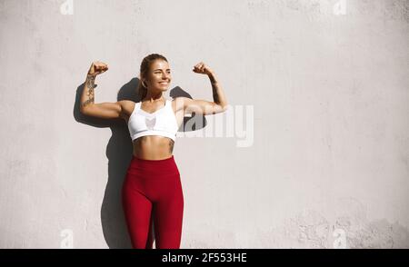 young sporty woman with dumbbells flexing biceps Stock Photo - Alamy
