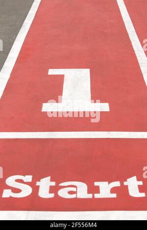 Red running racetrack on the outdoor athletic stadium, starting line. Stock Photo