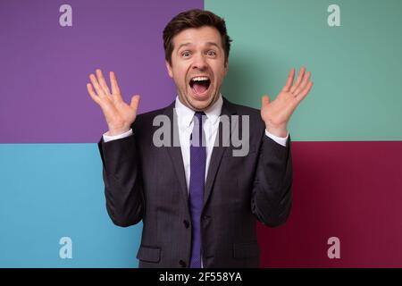 Cheerful excited handsome mature businessman being excited with news. Studio shot Stock Photo
