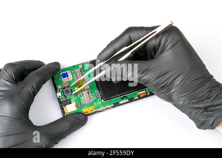 Fix the phone.A technician or master repairs a mobile phone, he installs and changes the camera in the motherboard. Hands, gloves, macro Stock Photo