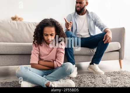 Family Conflict. Angry black father scolding sad daughter Stock Photo