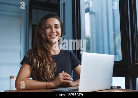 Happy smart woman working from home, freelancer using computer, work with laptop remote during self-quarantine, virus outbreak, stay safe and Stock Photo