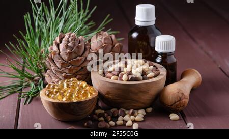 natural product cedar nut oil with glass bottles and cones on a wooden table Stock Photo