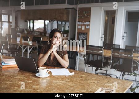 Charming female successful stylish businesswoman sitting co-working modern cafe drinking coffee prepare papers future meeting partners use laptop Stock Photo