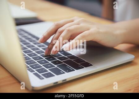 Closeup of businesswoman hands on laptop at office desk. woman using laptop for searching web or browsing information, home office concept. Stock Photo