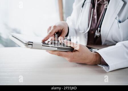 Female doctor using digital tablet at desk in hospital Stock Photo