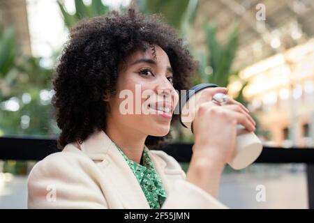 Thoughtful young woman having coffee at cafe Stock Photo