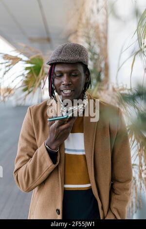 African man talking on smart phone through speaker Stock Photo