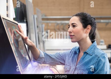 Businesswoman operating control panel screen in factory Stock Photo