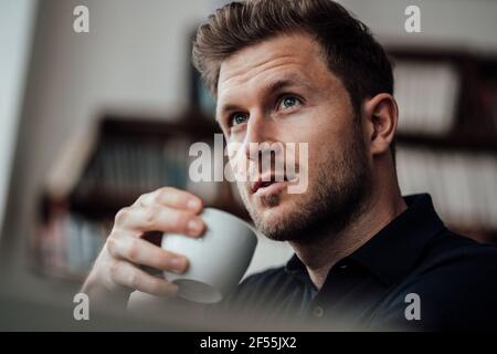 Thoughtful businessman looking away while having coffee at cafe Stock Photo