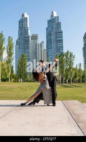 Male and female Tango dancers practicing in public park Stock Photo