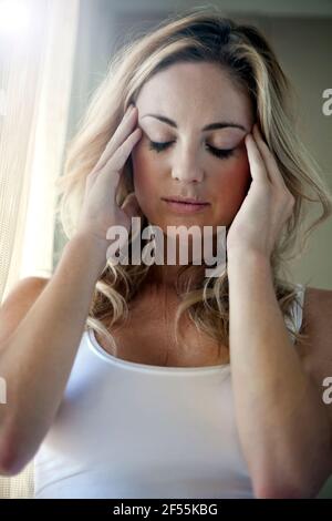 Young woman having headache at home Stock Photo