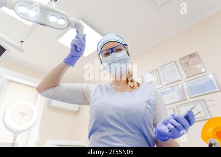 Portrait of female dentist wearing protective face mask working at office Stock Photo