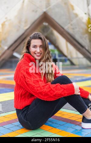 Beautiful woman sitting on multi colored tiled floor Stock Photo