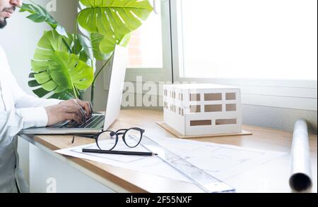 Young male architect using laptop at desk in office Stock Photo