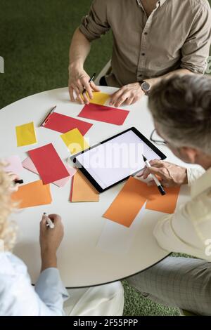 Male and female entrepreneurs writing on papers at table in office Stock Photo