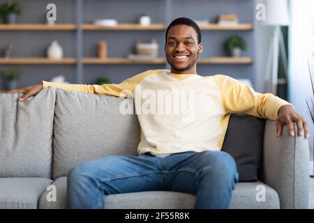 Relaxed african american man resting on sofa at home Stock Photo