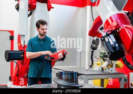 Male engineer operating control at machinery in factory Stock Photo
