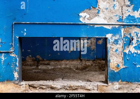 Old blue grungy wall with tubes in an uninhabited building or factory Stock Photo