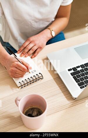 Woman writing in Chinese on note pad at home Stock Photo
