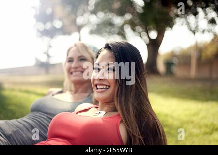 Cheerful young woman with female friend at park Stock Photo