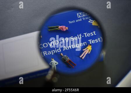 A COVID-19 Self Test (Rapid Antigen Test) kit information concept image. Selective focus through a magnifying glass. Stock Photo